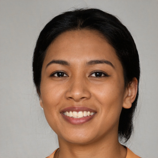 Joyful latino young-adult female with medium  black hair and brown eyes