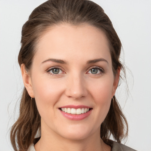 Joyful white young-adult female with medium  brown hair and grey eyes