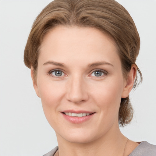 Joyful white young-adult female with medium  brown hair and grey eyes