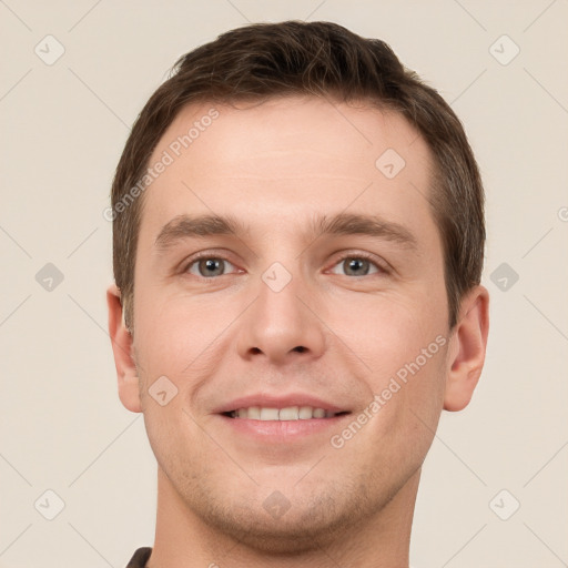 Joyful white young-adult male with short  brown hair and grey eyes