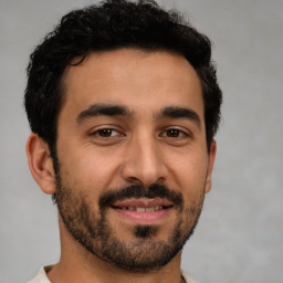 Joyful latino young-adult male with short  black hair and brown eyes