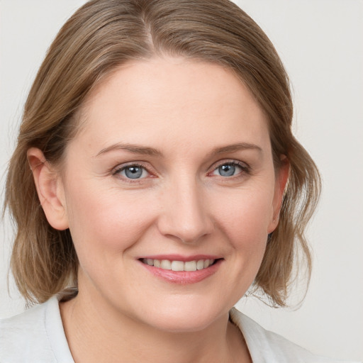 Joyful white young-adult female with medium  brown hair and blue eyes