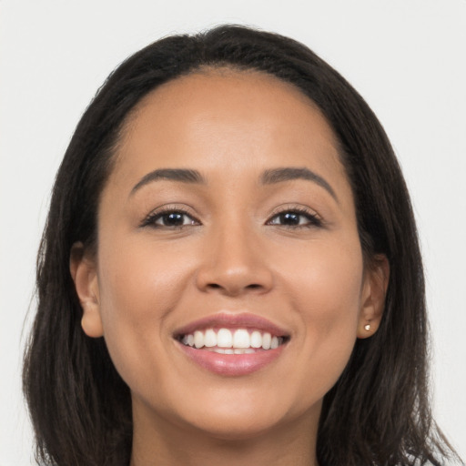 Joyful latino young-adult female with long  brown hair and brown eyes