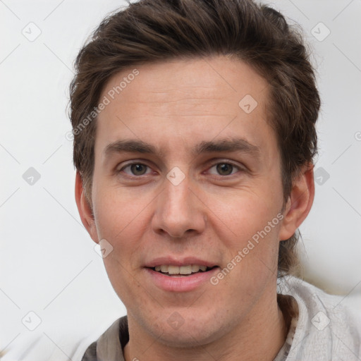 Joyful white adult male with short  brown hair and brown eyes