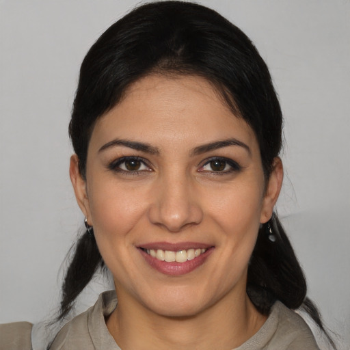 Joyful latino young-adult female with medium  brown hair and brown eyes