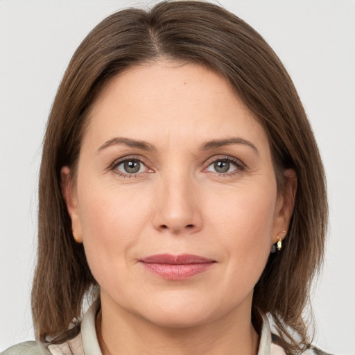 Joyful white adult female with medium  brown hair and grey eyes