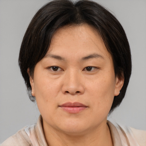 Joyful asian adult female with medium  brown hair and brown eyes