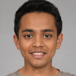 Joyful latino young-adult male with short  black hair and brown eyes