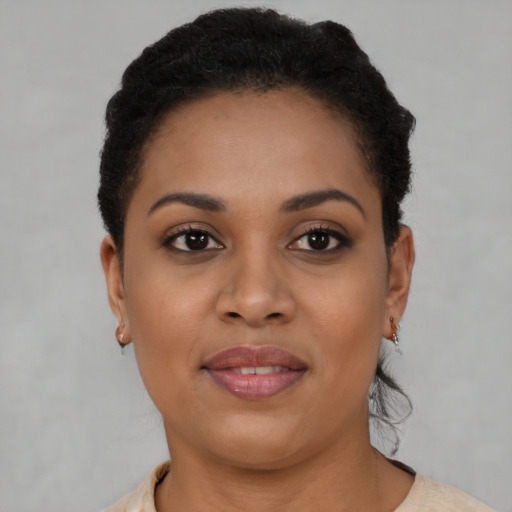 Joyful black young-adult female with short  black hair and brown eyes