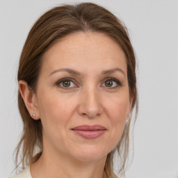 Joyful white adult female with medium  brown hair and grey eyes