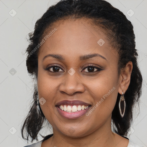 Joyful black young-adult female with long  brown hair and brown eyes