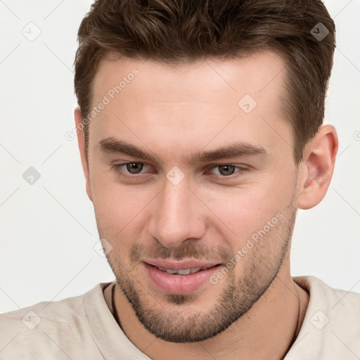 Joyful white young-adult male with short  brown hair and grey eyes