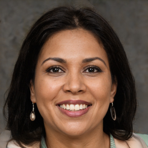 Joyful latino adult female with medium  brown hair and brown eyes