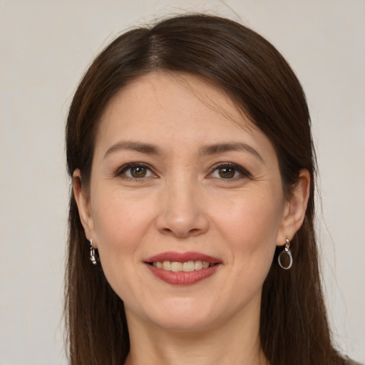 Joyful white young-adult female with long  brown hair and brown eyes