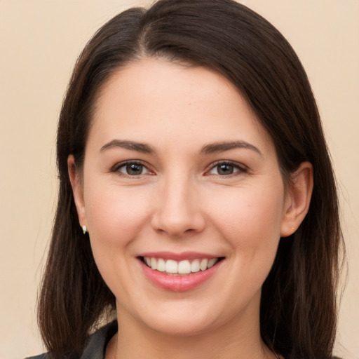 Joyful white young-adult female with long  brown hair and brown eyes