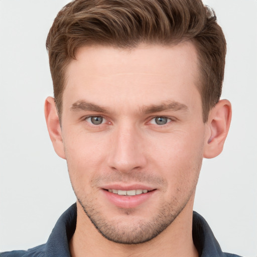 Joyful white young-adult male with short  brown hair and grey eyes