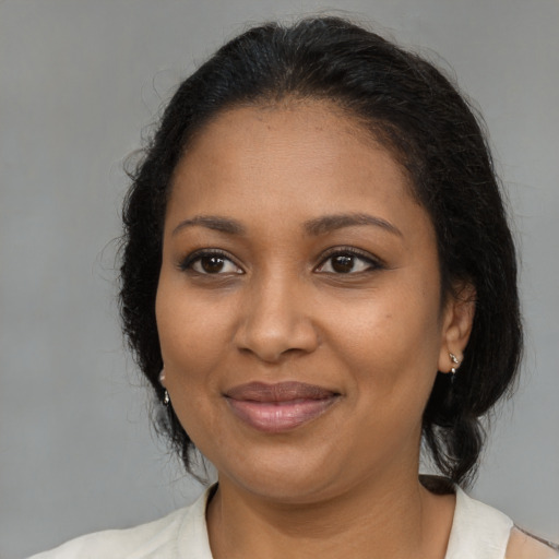 Joyful black adult female with medium  black hair and brown eyes