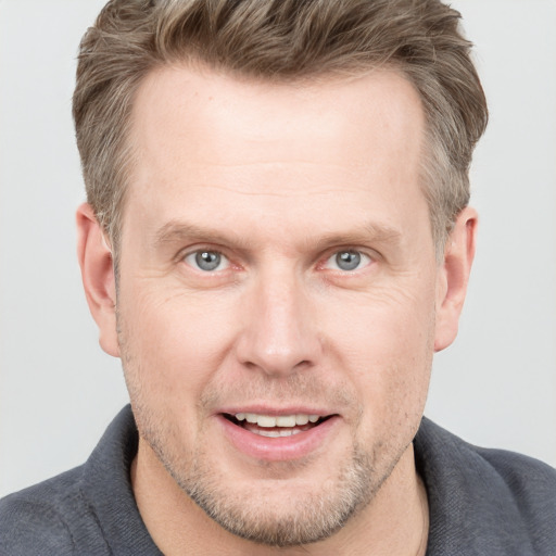 Joyful white adult male with short  brown hair and grey eyes