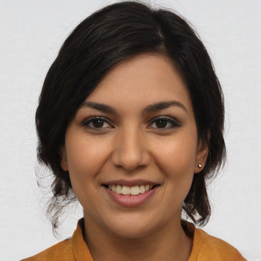 Joyful latino young-adult female with medium  brown hair and brown eyes