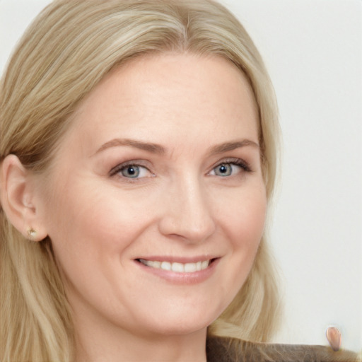 Joyful white young-adult female with long  blond hair and grey eyes