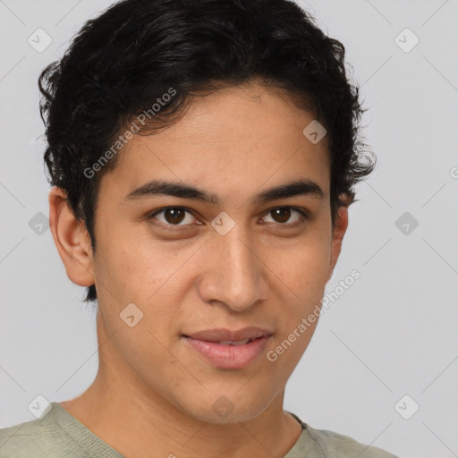 Joyful latino young-adult male with short  brown hair and brown eyes