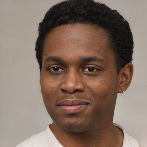 Joyful black young-adult male with short  black hair and brown eyes