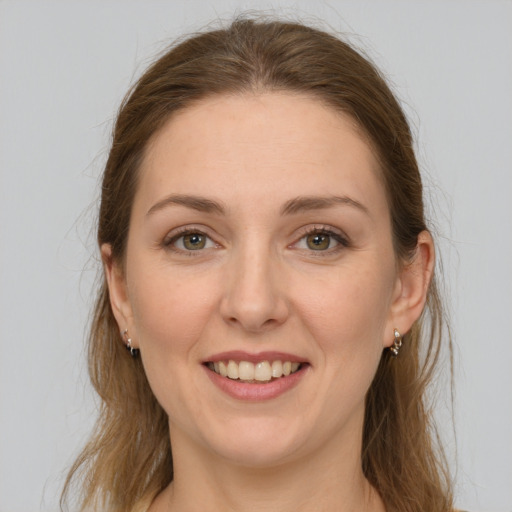 Joyful white young-adult female with long  brown hair and grey eyes