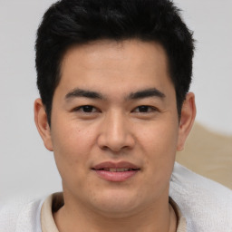 Joyful asian young-adult male with short  brown hair and brown eyes