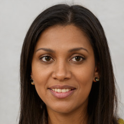 Joyful black young-adult female with long  brown hair and brown eyes