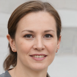 Joyful white adult female with medium  brown hair and grey eyes