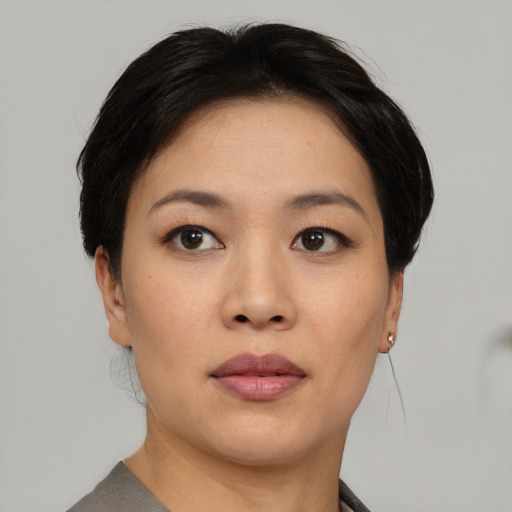 Joyful asian young-adult female with short  brown hair and brown eyes