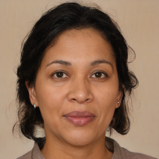 Joyful latino adult female with medium  brown hair and brown eyes