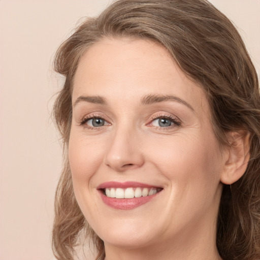 Joyful white young-adult female with medium  brown hair and green eyes