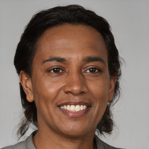 Joyful latino adult female with medium  brown hair and brown eyes