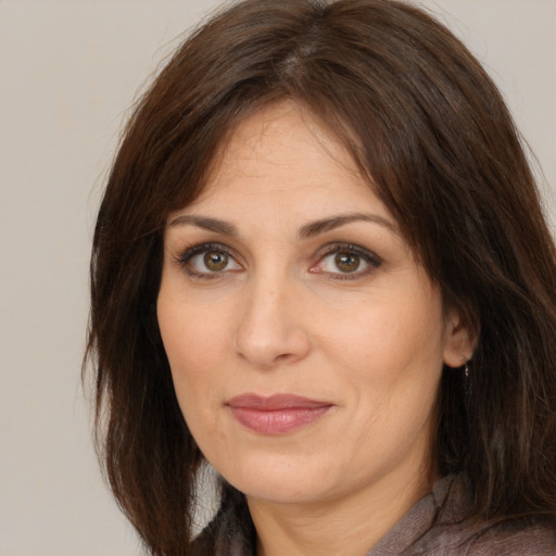 Joyful white adult female with long  brown hair and brown eyes