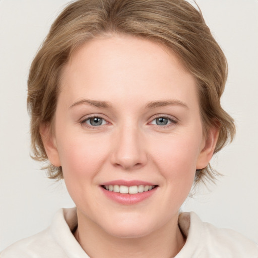 Joyful white young-adult female with medium  brown hair and blue eyes