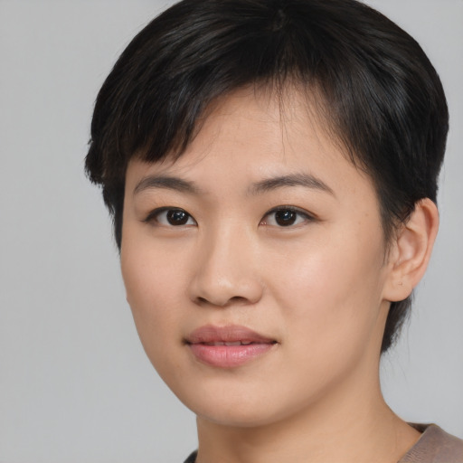 Joyful asian young-adult female with short  brown hair and brown eyes
