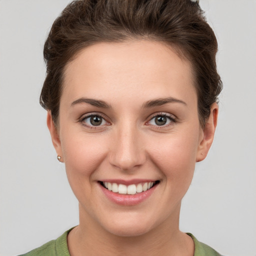 Joyful white young-adult female with short  brown hair and grey eyes