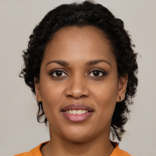 Joyful black young-adult female with long  brown hair and brown eyes