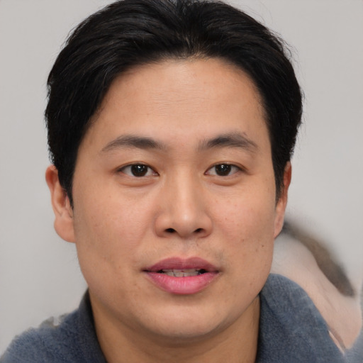 Joyful asian young-adult male with short  brown hair and brown eyes