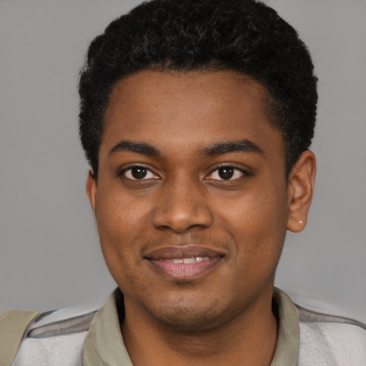 Joyful black young-adult male with short  black hair and brown eyes