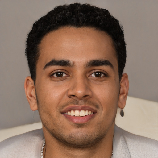 Joyful latino young-adult male with short  black hair and brown eyes