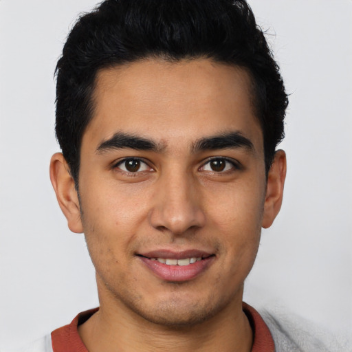 Joyful latino young-adult male with short  brown hair and brown eyes