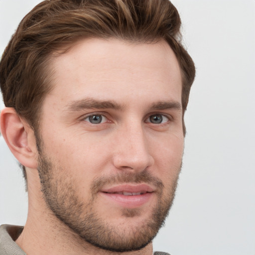 Joyful white young-adult male with short  brown hair and grey eyes