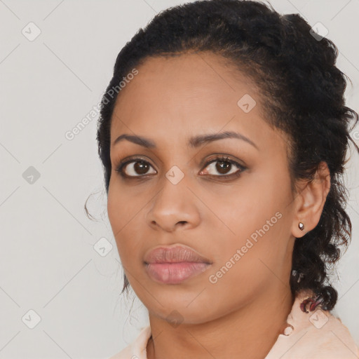 Joyful black young-adult female with long  black hair and brown eyes