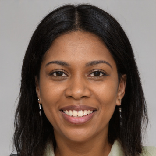 Joyful black young-adult female with long  brown hair and brown eyes