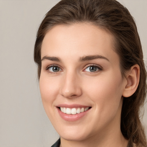 Joyful white young-adult female with long  brown hair and grey eyes