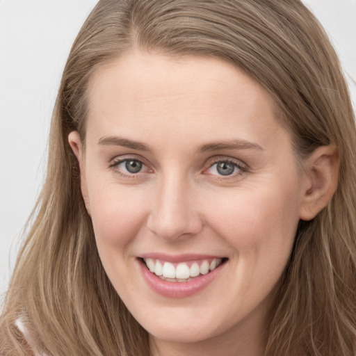 Joyful white young-adult female with long  brown hair and grey eyes