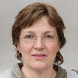 Joyful white adult female with medium  brown hair and blue eyes