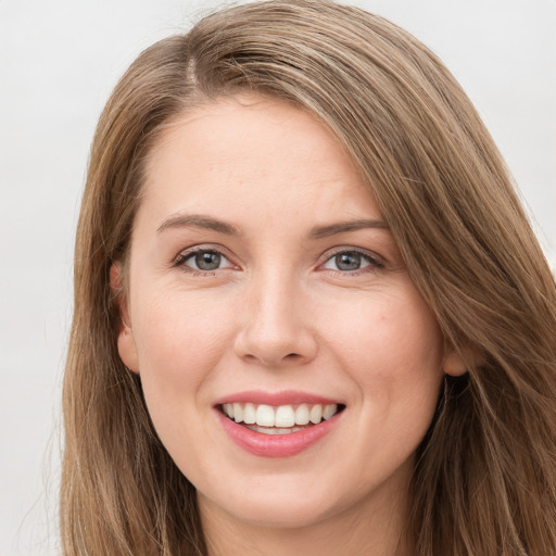 Joyful white young-adult female with long  brown hair and grey eyes